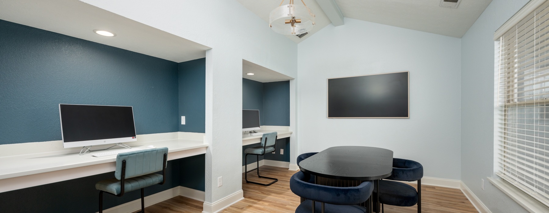 Room with computer, tables, and tv