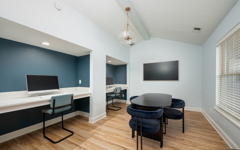 Room with computer, tables, and tv