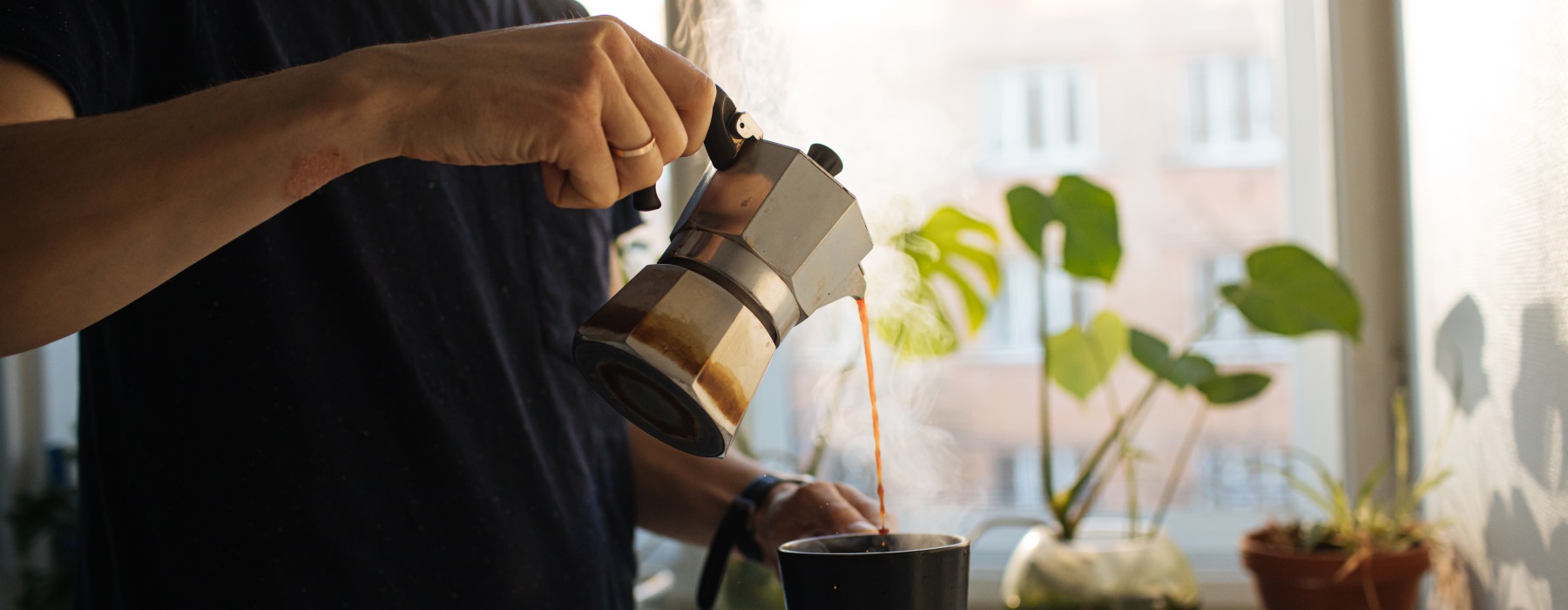 Person making coffee with plants around them